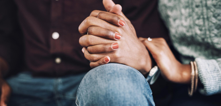 Close up of male and female holding hands