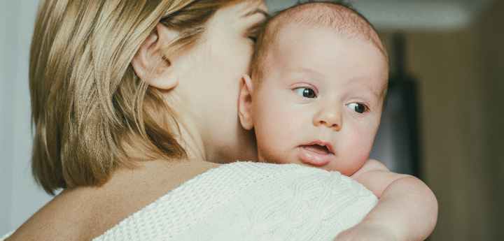 Baby on shoulder of blonde woman