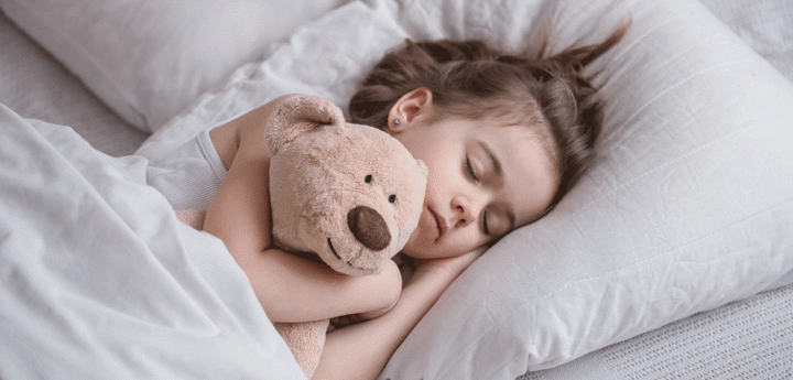 Little girl in bed with toy