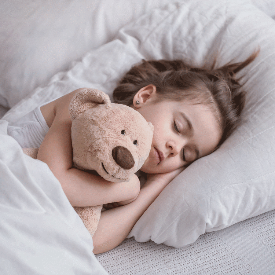 Little girl in bed with toy