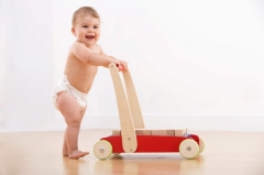 Baby in nappy walking with push and pull toy