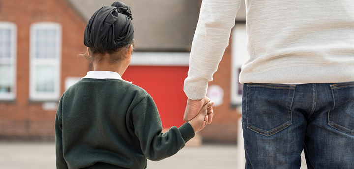 primary school aged Sikh boy holding the hand of an adult