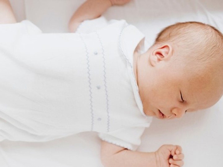 Baby lying on back in crib