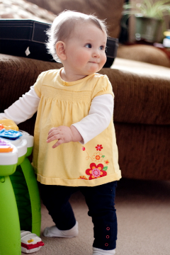 Baby standing and holding onto table console toy