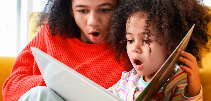 Adult And Child Reading Book Together With Mildly Shocked Expression