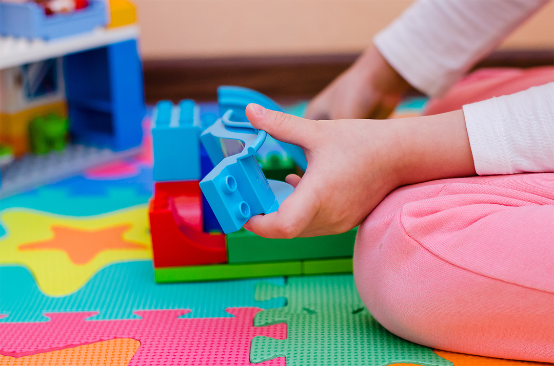 child playing with Duplo blocks