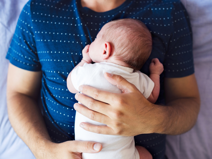 baby lying on man's chest