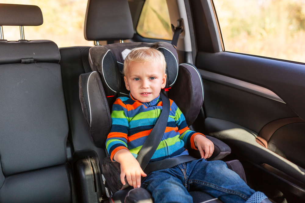 Young boy sitting in a front facing car seat