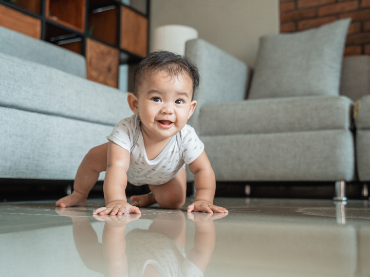 Baby crawling on floor in a living room
