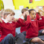 Children In Classroom Sitting And Singing Songs With Actions