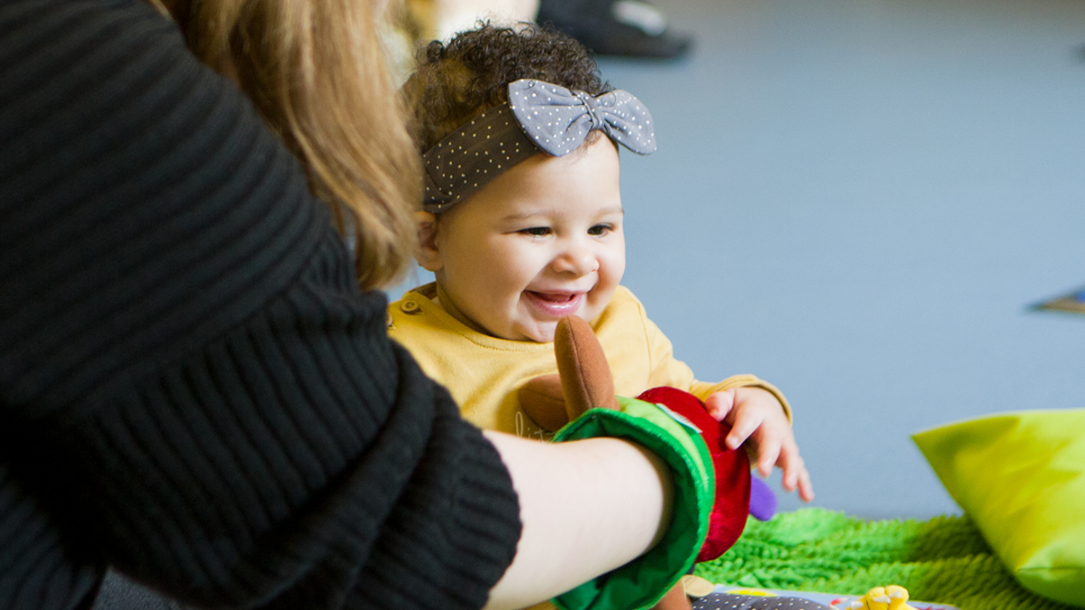 child giggling with hand puppet