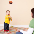 baby standing while throwing a ball