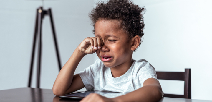 crying boy at table